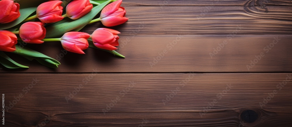Poster close up of a vibrant tulip frame against a rustic wooden background providing ample copy space for 