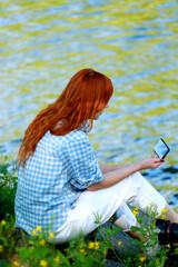 Vacation by the river. A girl strolling along the river on a beautiful summer day. Joy, happiness,The girl sees the river. serenity.