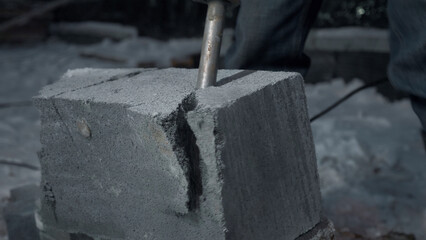 Man drills cement blocks. Clip. Worker splits cement blocks at construction site with hammer drill....