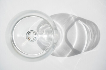 Empty wine or shot glass seen from above with shadow on white background. Focus on the inner ring