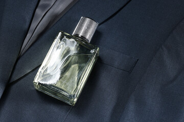 Luxury men's perfume in bottle on grey jacket, space for text