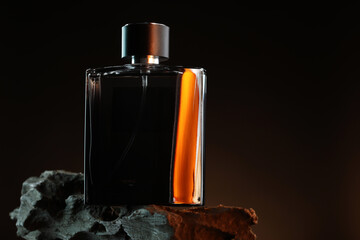 Luxury men`s perfume in bottle against dark background, space for text