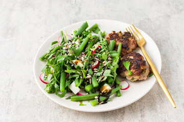 Delicious lunch or breakfast, salad with arugula and asparagus beans, radishes and various seeds,...