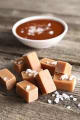 Yummy caramel candies with sea salt on wooden table, closeup