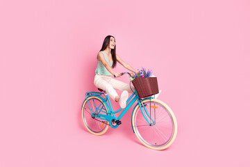 Photo of positive charming cute woman wear stylish clothes drive bicycle empty space isolated on...