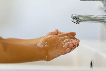 close up hands of children washing hands with soap under the faucet with water,copy space for text...