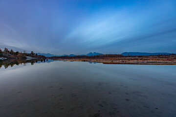 Fraser River at sunset, dusk, or twilight with log booms in the distance