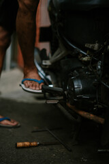 A motorcycle mechanic inspecting a damaged engine