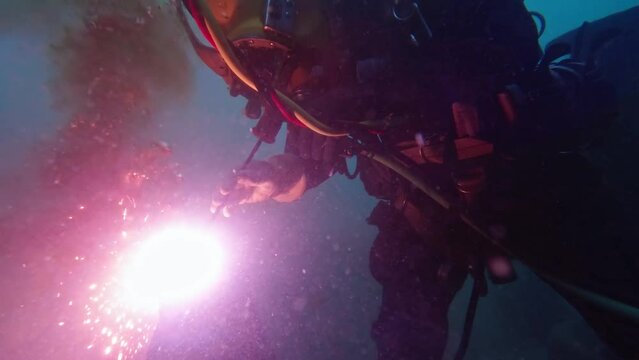 Commercial diver cutting steel underwater closeup
