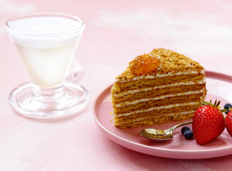 honey cake dessert on a plate on a pink background