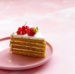 honey cake dessert on a plate on a pink background