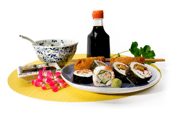 sushi dinner with miso soup on a yellow place mat isolated on white