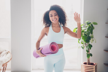 Photo of positive charming woman sportswear enjoying pilates waving arm hi indoors house apartment...