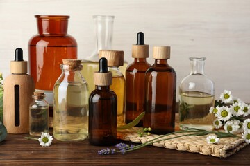 Aromatherapy. Different essential oils and flowers on wooden table
