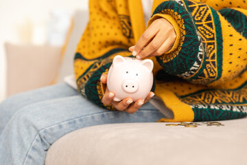 Saving money investment for future. Female woman hands holding pink piggy bank and putting money...