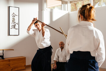 Aikido Instructors Practicing Jo Staff Techniques in Dojo Setting