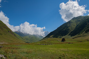 Obraz premium Mountain's Embrace: Green Peaks Cradled by the Azure Sky