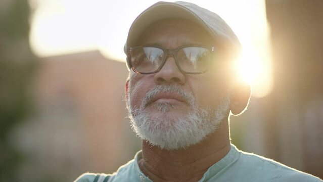 Senior inspired hispanic latino man in the city at sunset - Portrait of old retired person