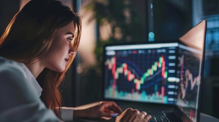 A businesswoman reviewing stock market performance graphs and charts on a laptop computer at her office desk.