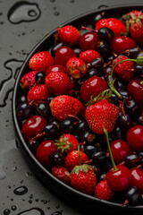 Berries on a black plate on a black background