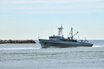 Russian warship armed with armament sails into sea toward military target to attack and destroy enemy, military ship performing strategic maneuver, Russian sea power deployment for tactical advantage
