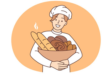 Smiling male baker with basket of fresh bread