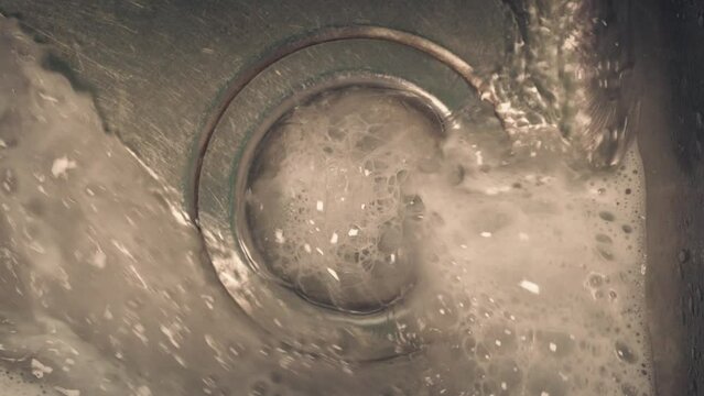 Soapy Water Washes Down Sink Closeup