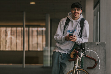 young underground man with mobile phone and vintage bicycle, urban scene