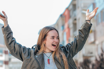 urban blonde girl on the street excited with joy