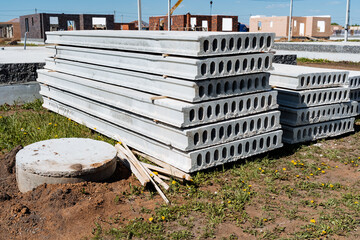 A stack of concrete blocks at a construction site demonstrates preparation for building foundation,...