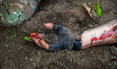 Hand of a wounded soldier covered in blood