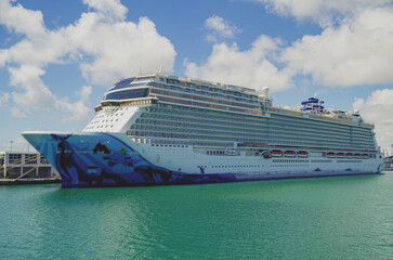 Big modern cruiseship or cruise ship liner Bliss in Port of Miami, Florida with downtown skyline...