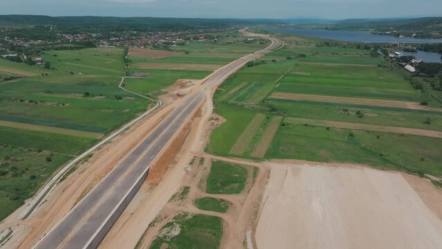 Romania A1 highway construction site. Aerial 4k video of A1 road that connects Bucharest Pitesti highway with Curtea de Arges and Sibiu. Infrastructure construction industry in Romania.