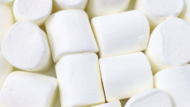 White tasty sugar marshmallow candy pieces circle rotation close up top view