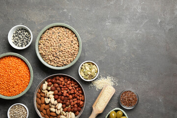 Different products high in natural fats on grey table, flat lay. Space for text