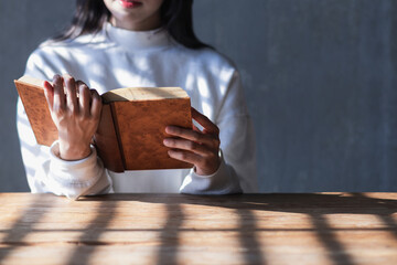 The young woman held a Bible in her hand and tried to learn and understand God teachings from the...