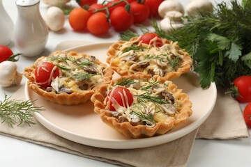 Tasty tartlets with cheese, tomatoes, mushrooms and dill on white table, closeup