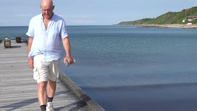 Tisvilde, Denmark A man walks on a boardwalk on the beach in North Zealand on the Kattegat.