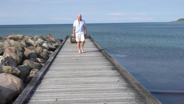 Tisvilde, Denmark A man walks on a boardwalk on the beach in North Zealand on the Kattegat.