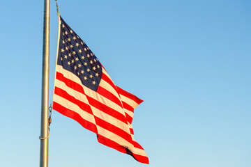 America national flag fluttering against clear sky at sunset. Copy space.