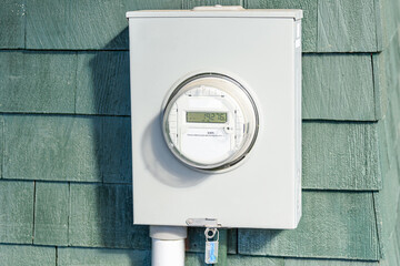 Close up of a smart electricity meter on a external wooden wall
