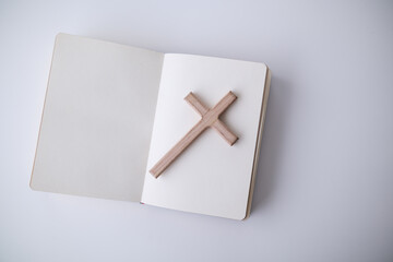 cross is placed on the Bible after prayer to God, which is religious ritual of Christianity and...