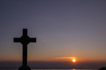 The silhouette of a cross on the background of a twilight sunset is a symbol of God and the cross...