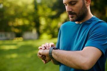 Close up of man using smart watch during outdoor workout.