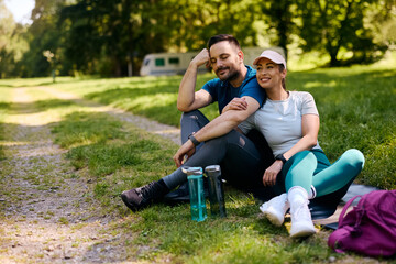 Fototapeta premium Athletic couple relaxing after exercising in park.