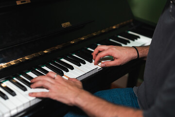 Musician playing a classic black piano in dim lighting