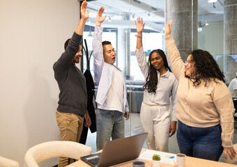 Celebratory high-five among coworkers in office