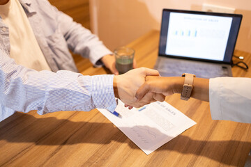 Coworkers sealing a deal with a handshake in an office