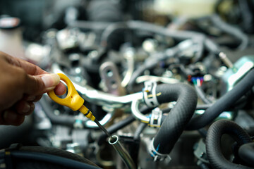 Obraz premium Hands man auto mechanic checking lube oil level of car engine on car engine background for maintenance or repair service concept.