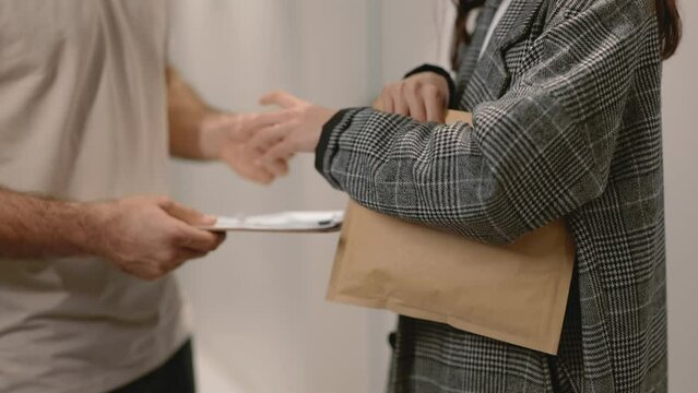 Close-up of hands exchanging an envelope, implying confidential or important document delivery between two people.